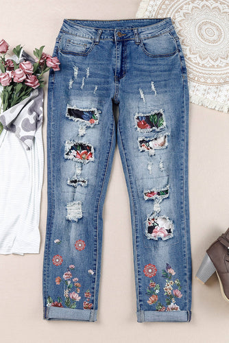 Jeans invecchiati patchwork con grafica floreale
